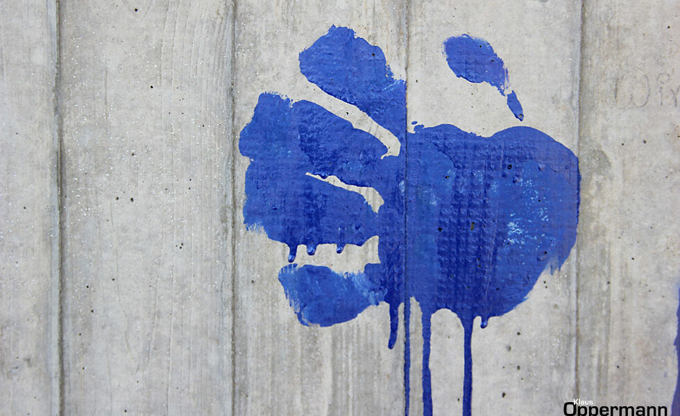 Betonwand Handabdruck blau